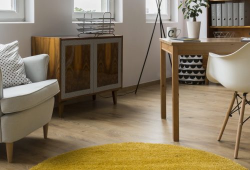 Stylish but cosy interior with comfortable armchair, simple white chair, desk and ethnic commode, panorama